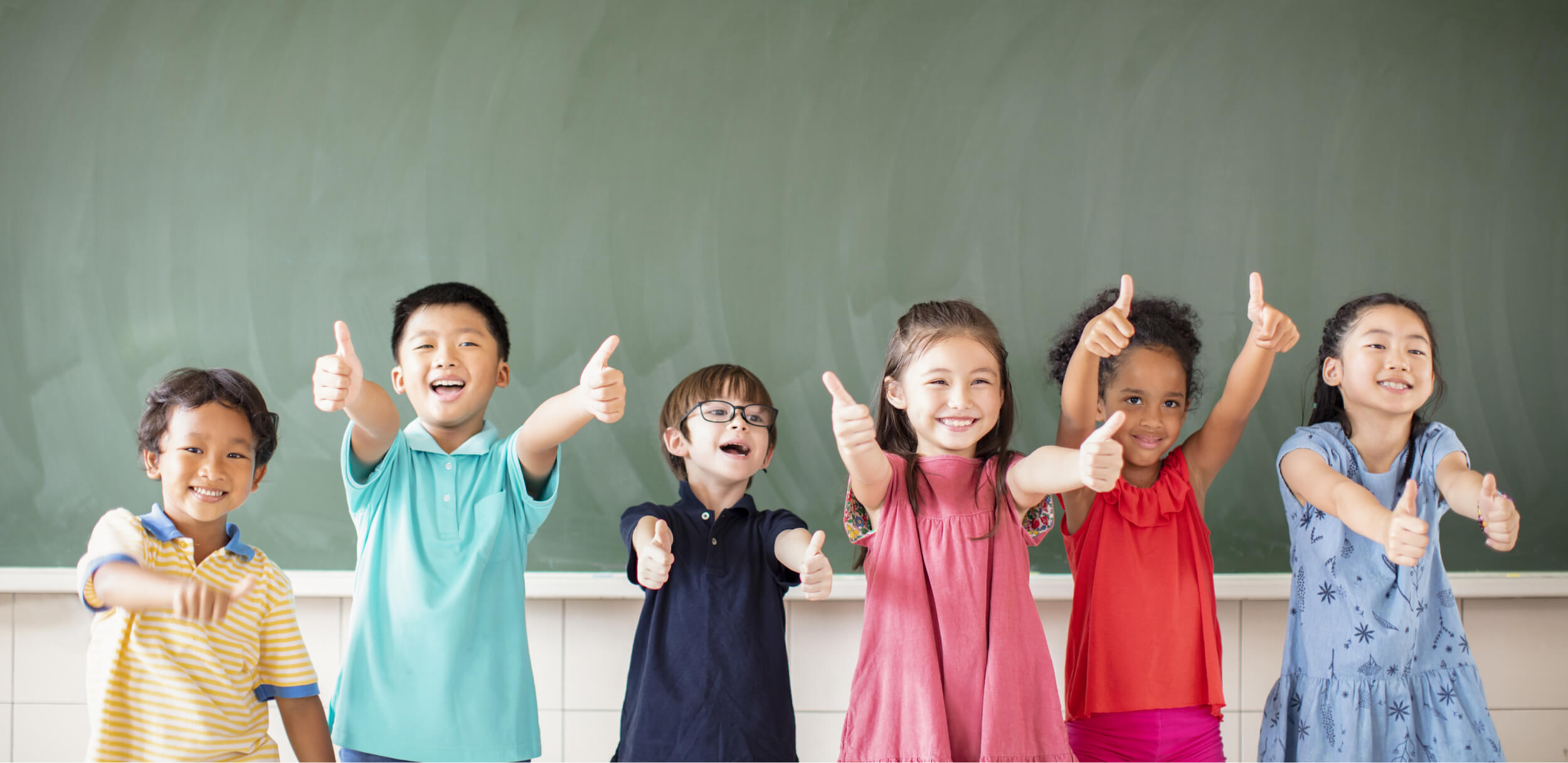 A group of children giving a thumbs up.