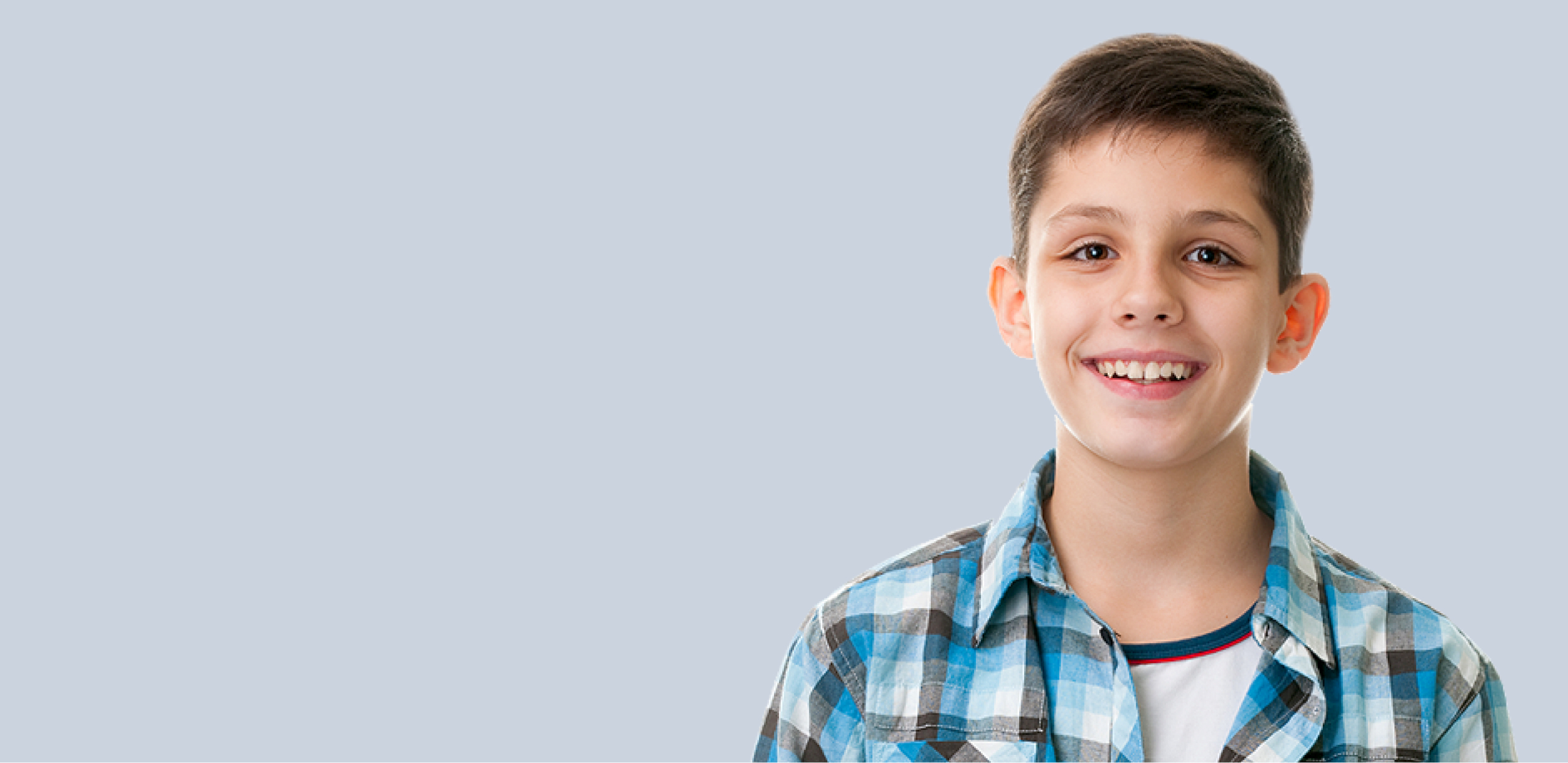 A teenager smiling against purple background.
